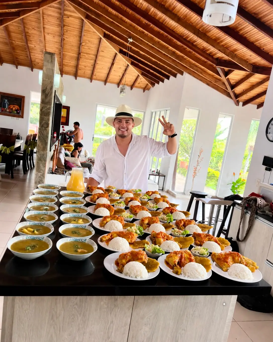 Jhon Varela junto a la mesa servida con sancocho, arroz, pernil de pollo en salsa criolla y tostadas de plátano