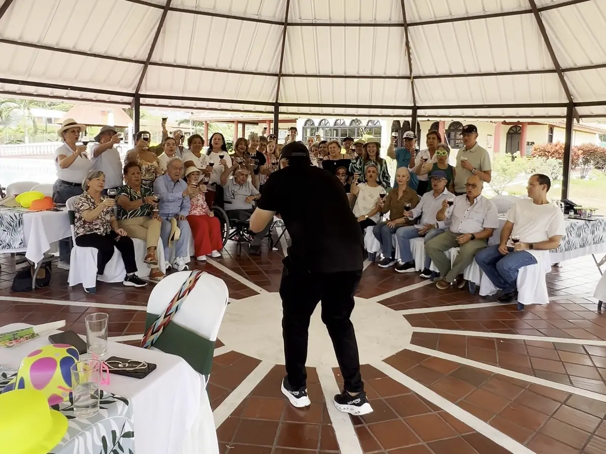 Grupo brindando bajo el kiosco de una finca durante un evento organizado por Jhon Varela